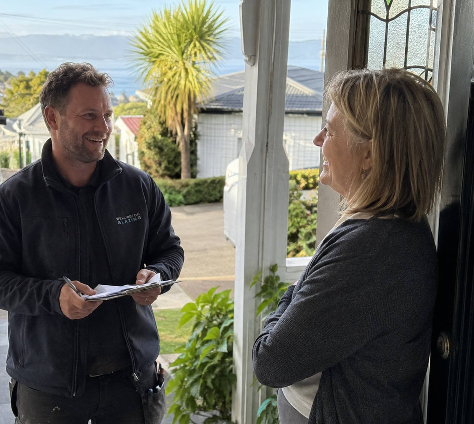 Window Repair Wellington glazier talking a homeowner through a written quote at her front door